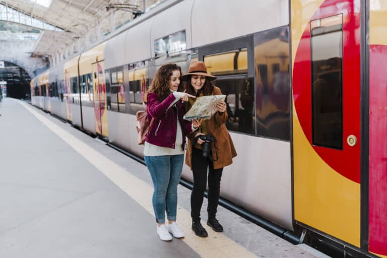 Zwei Frauen am Bahnhof prüfen eine Karte – moderne Schließanlage für sicheren Zugang zu Bahnhofsgebäuden