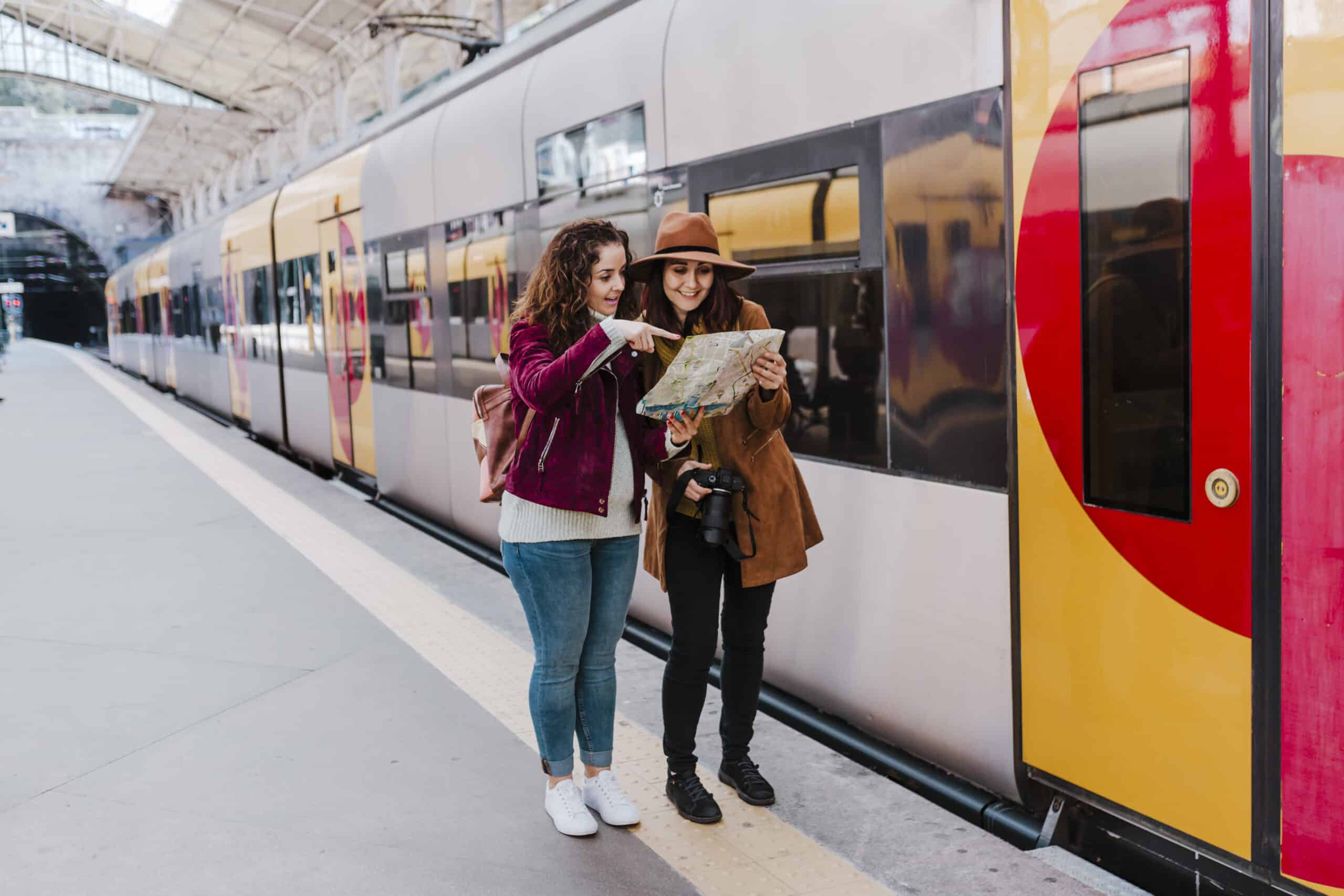 Zwei Frauen am Bahnhof prüfen eine Karte – moderne Schließanlage für sicheren Zugang zu Bahnhofsgebäuden